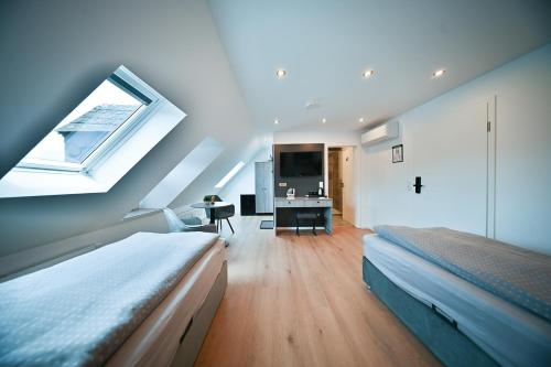 a bedroom with two beds and a desk and a window at Hotel M&H Apartments - Salzgitter in Salzgitter