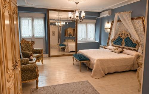 a bedroom with a bed and a chair and a mirror at Hostal Boutique Puerta del Sol in Torrelavega