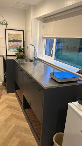 a kitchen with a counter with a sink and a window at Follies Garden Studio in Dungarvan