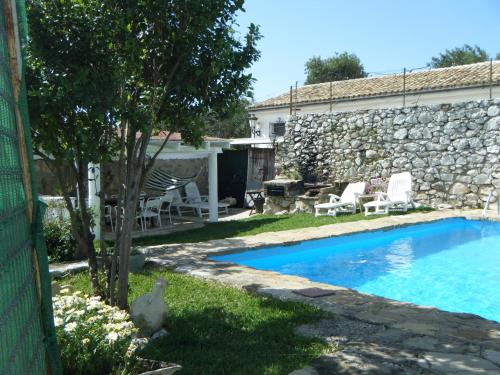 un cortile con piscina e un muro in pietra di Casa Nani a Benaocaz