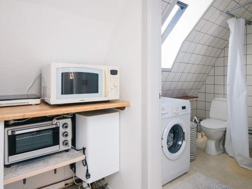 a kitchen with a microwave and a washer and dryer at 2 person holiday home in Ringkøbing in Ringkøbing
