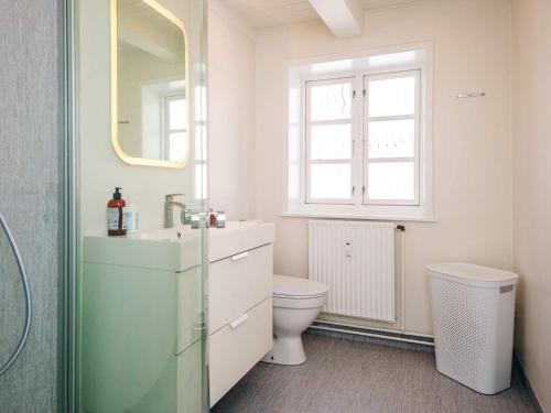 a bathroom with a toilet and a sink and a window at Holiday home in Ringkobing in Ringkøbing