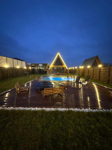 a patio with chairs and a pool at night at İstiridye Bungalov in Samsun
