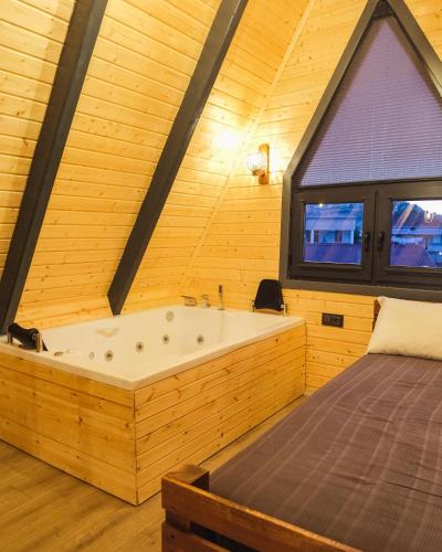 a bedroom with a large tub and a bed at İstiridye Bungalov in Samsun