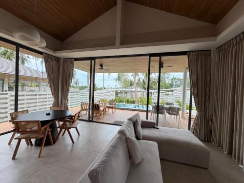 a living room with a couch and a table at Wave Villa New 2BR Pool Villa in Ko Phangan