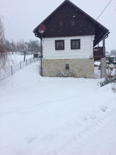 a house with a bike parked in the snow at Roubenka Doubravice in Hrubá Skála