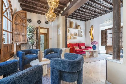 a living room with blue chairs and a red couch at BnS Dauro Suites in Granada