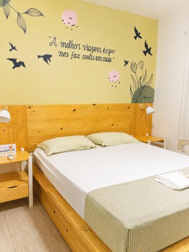 a bedroom with a bed with birds and flowers on the wall at Residencial Villa Jeri - AP with balcony, optional BREAKFAST in Jericoacoara