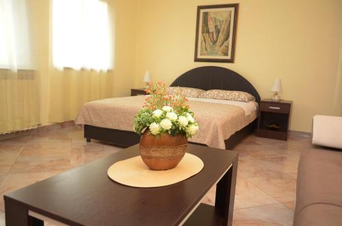a bedroom with a bed and a table with a pot of flowers at Apartment Adela in Kotor