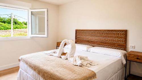 a bedroom with a bed with a cat laying on it at O Retiro da Costa Galitrips in Muxia