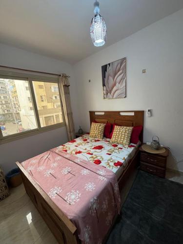 a bedroom with a large bed with a pink comforter at The Sonu Nest in Dakar