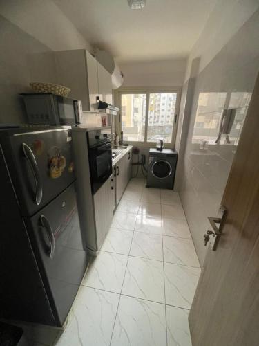 a kitchen with a refrigerator and a washing machine at The Sonu Nest in Dakar