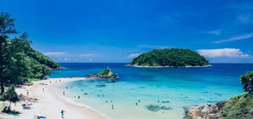a group of people on a beach in the ocean at Loft at Rawaï Beach in Nai Harn Beach