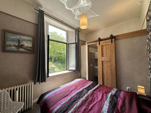 a bedroom with a bed and a window at La Tulipe in Vireux-Molhain
