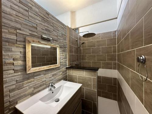 a bathroom with a sink and a mirror and a tub at La Tulipe in Vireux-Molhain