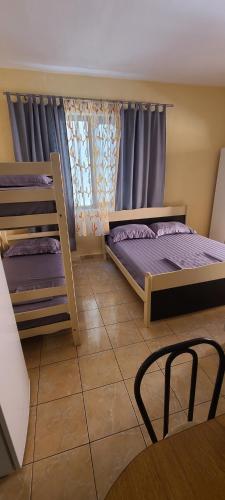 a bedroom with two bunk beds and a chair at ℰ`ℋ Hotel - Velipoje rruga nr 7 in Velipojë