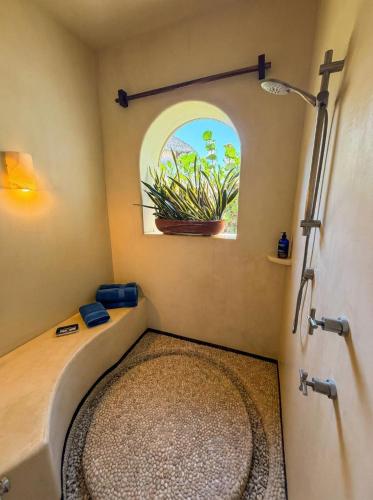 a bathroom with a tub and a window and a plant at Residences at Las Palmas in Zihuatanejo