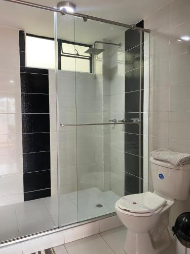 a bathroom with a glass shower with a toilet at Hotel Posada Leon in Pasto