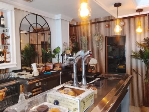 a bakery with a counter with doughnuts in at Hostal Avenida Pozo Alcón in Pozo Alcón