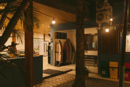 a room with a room with surfboards on the wall at Sea Wolf Surf Hostel Campeche in Florianópolis
