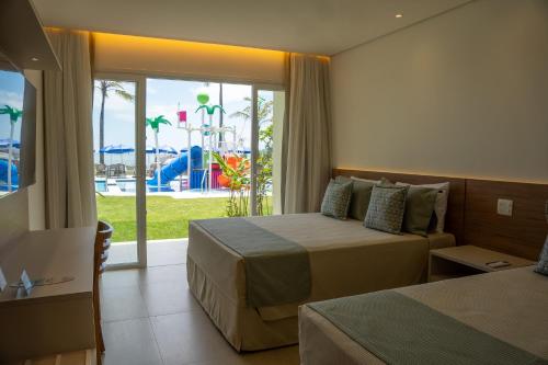 a hotel room with two beds and a view of a playground at Beach Hotel Paúba in São Sebastião