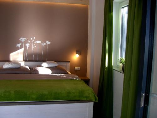 a bedroom with a green bed and a window at Alpine Appartement in Oetz