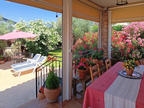 a porch with a table and chairs and flowers at Casa Rural Dani. Escalona in Toledo