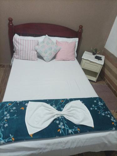 a bed with a blue blanket with a bow on it at Pousada Refúgio da Chapada in Cavalcante