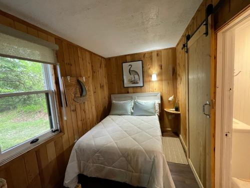 a bedroom with a bed in a room with a window at Tracadie Cottages in York