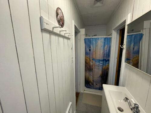 a white bathroom with a sink and a mirror at Tracadie Cottages in York
