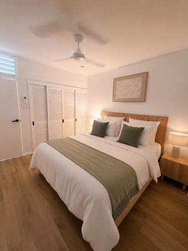a bedroom with a large white bed with two pillows at Stylish Tropical Villa with Lagoon Pool in Port Douglas