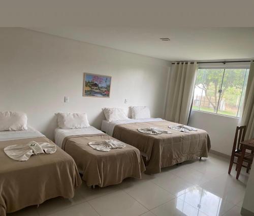 a hotel room with two beds and a window at Querência Pantaneira in Miranda