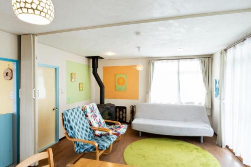 a living room with a couch and a chair at Joy House in Matsumoto