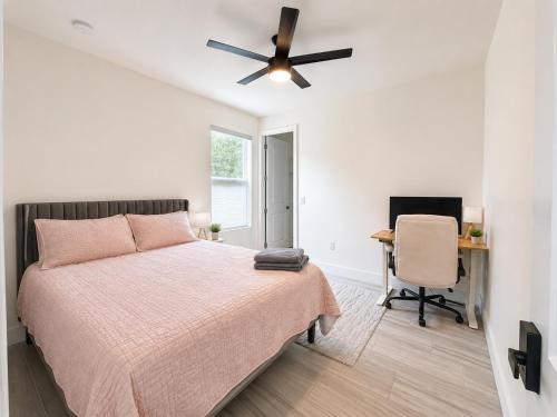 a bedroom with a bed and a desk and a ceiling fan at SpaceX R4 Shared in Orlando