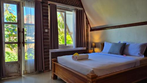 a bedroom with a large bed and a window at Green Haven Homestay in Tetebatu