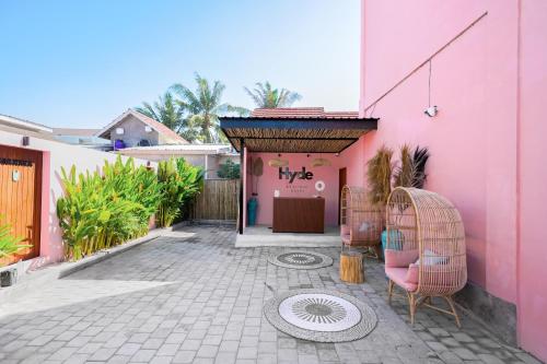 a pink building with two chairs in front of it at Hyde Boutique Hotel in Kuta Lombok