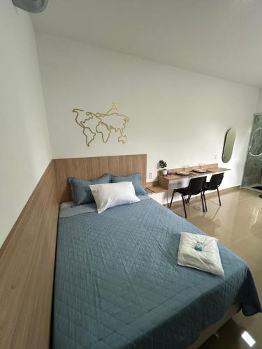 a bedroom with a blue bed and a table and chairs at Studio CG Tingui 1 in Estação Inhoaíba