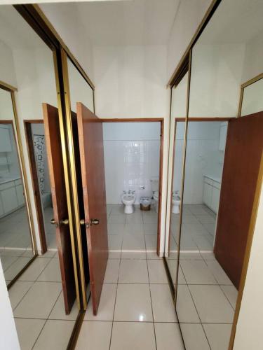 a bathroom with a toilet and a bathroom with glass doors at Villa in Miradero in Mayaguez