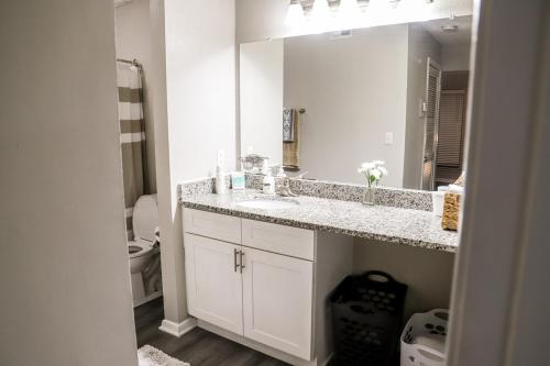 a white bathroom with a sink and a mirror at Cozy ATL Retreat in Decatur