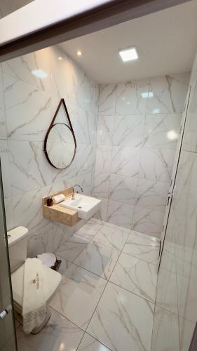 a white bathroom with a toilet and a sink at Hotel Vistta Iracema in Fortaleza