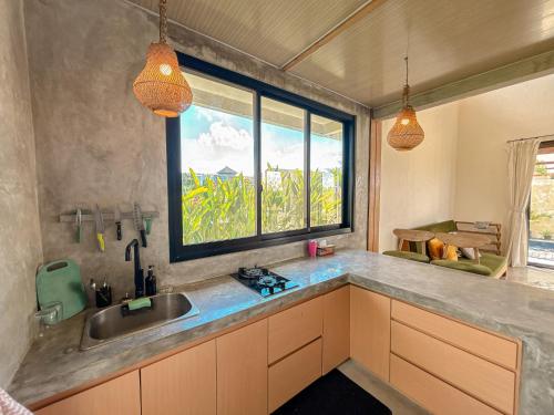 a kitchen with a sink and a window at Villa Umah Dangin Desa in Tanah Lot