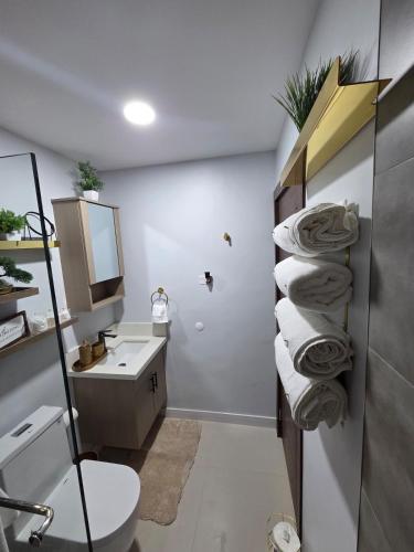 a bathroom with a sink and a toilet and towels at House of Harmony in Portmore