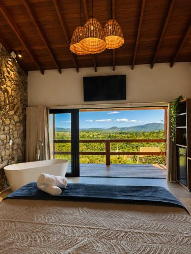 a bathroom with a tub and a tv and a window at Pousada Yvanna in Pirenópolis