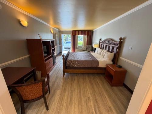 a bedroom with a bed and a desk and a television at Sunset Inn in Jacksonville