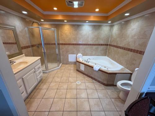 a bathroom with a tub and a shower and a toilet at Sunset Inn in Jacksonville