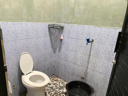 a bathroom with a toilet and a black bucket at LovKend in Ruteng
