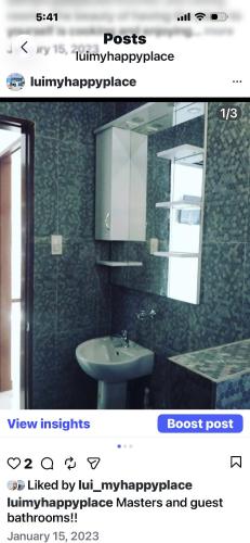 a picture of a bathroom with a sink and a mirror at Lui my happy place in Pandan