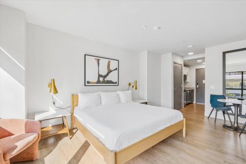 a bedroom with a large white bed and a couch at Kasa Capitol Hill Seattle in Seattle