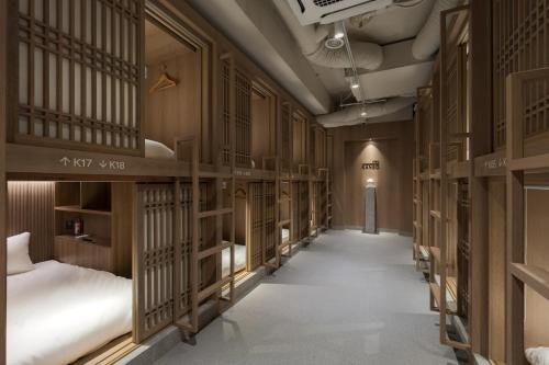 a hallway with rows of bunk beds in a room at Kanso Stay Jongno in Seoul