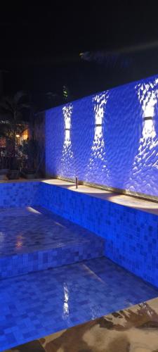 a blue stone wall with lights on it at night at Pousada Pouso Da Praia in Cumbuco